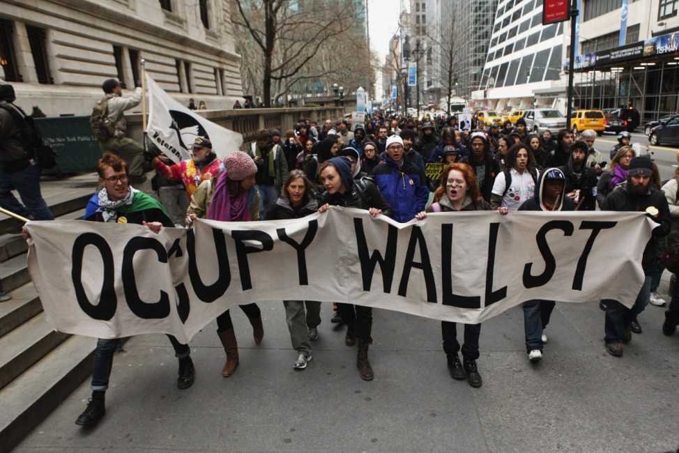 Members of the Occupy Wall St movement carry a sign during a 'national day of action' demonstration by the movement in New York