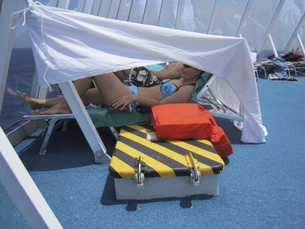 People rest on the Costa Allegra cruise ship in this handout picture taken by one of the passengers