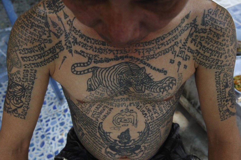 A man shows tattoos on his body at Wat Bang Phra in Nakhon Pathom province