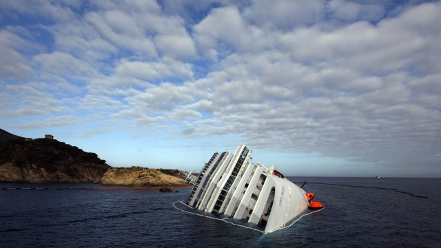 File photo of the Costa Concordia cruise ship on its side, half-submerged and threatening to slide into deeper waters