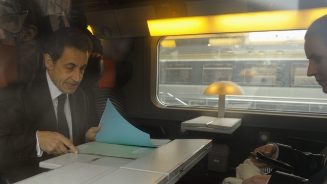 France's President Sarkozy sits in a TGV train before his departure for Lille