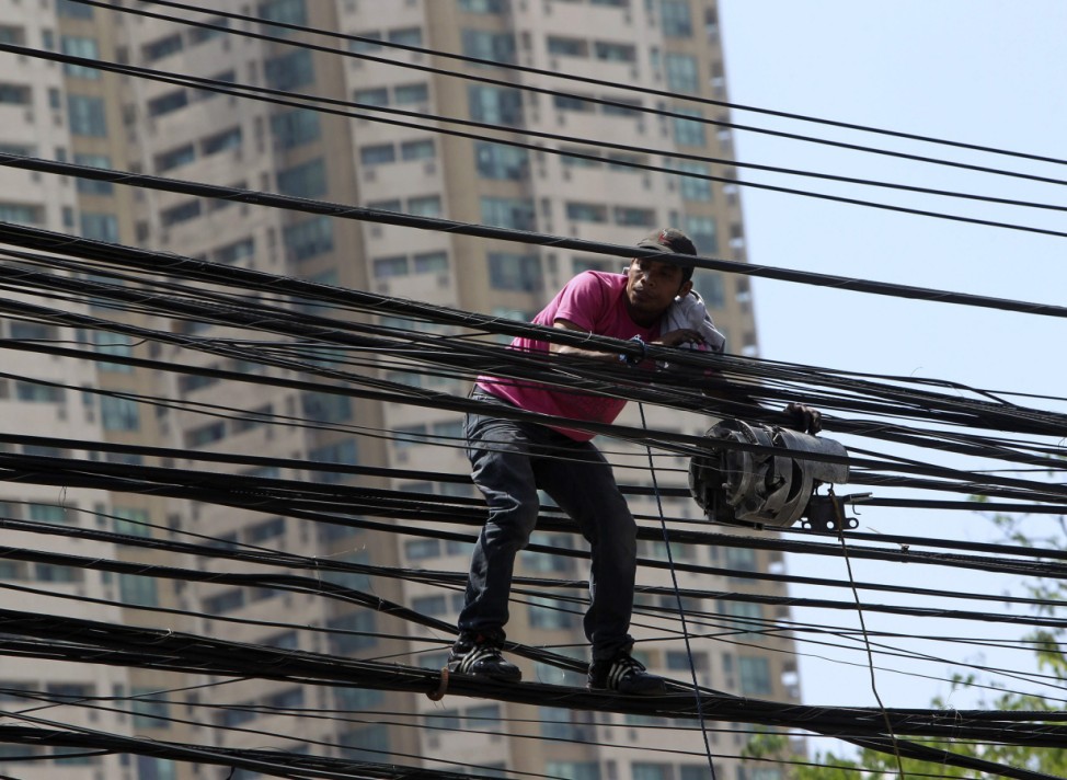 A worker of Globe Telecoms installs internet cables in Manila