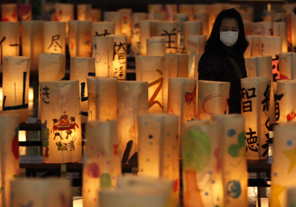 A woman looks at paper lanterns created at a memorial for the victims of the March 11 earthquake and tsunami in Koriyama