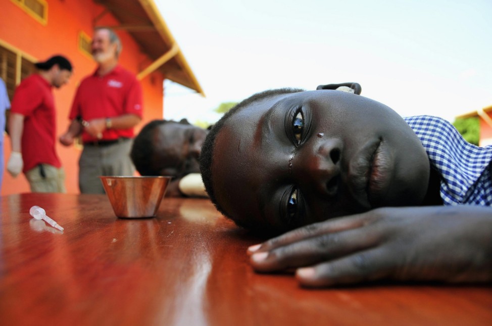 A girl with hearing challenges cries after her ears were cleaned during an event held by Starkey Hearing Foundation at St. Monica in Gulu