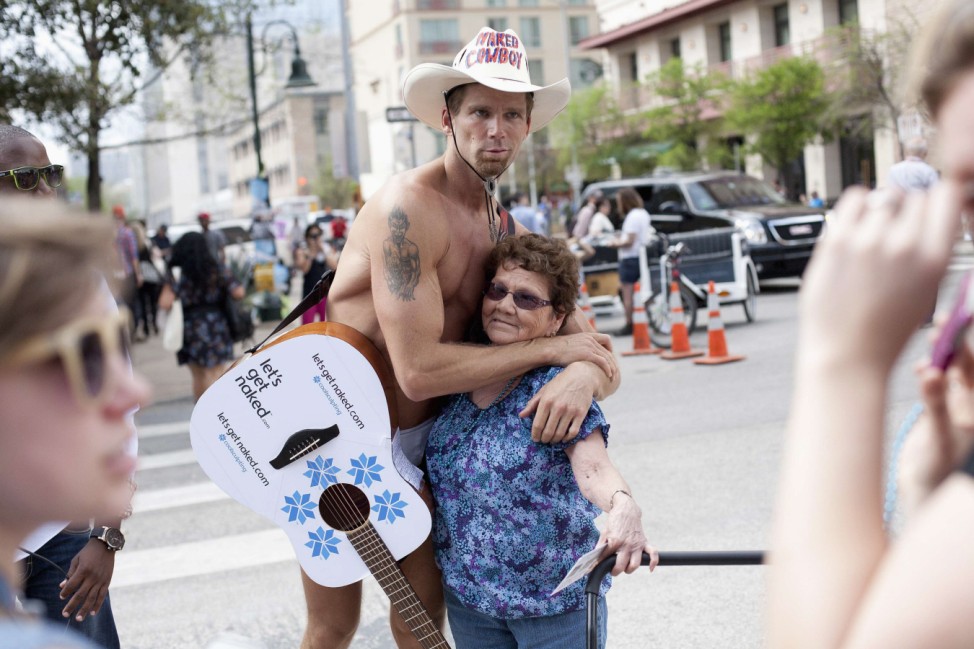 'Naked Cowboy' hugs a woman during the SXSW Music conference in Austin, Texas