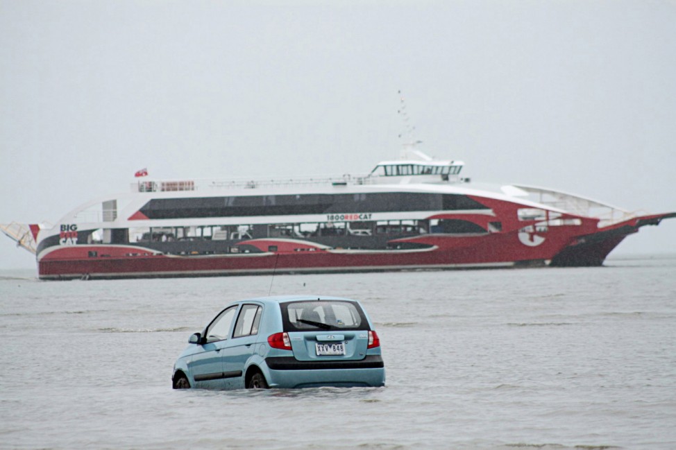 Ferry passes a rental car stranded in the ocean at Oyster Point