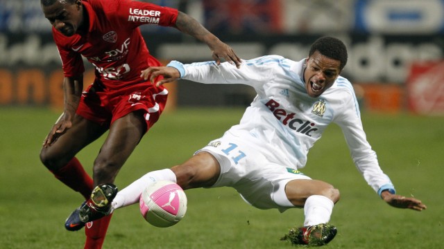 Olympique Marseille's Remy challenges Dijon's  Kakuta during their French Ligue 1 soccer match at the Velodrome stadium in Marseille