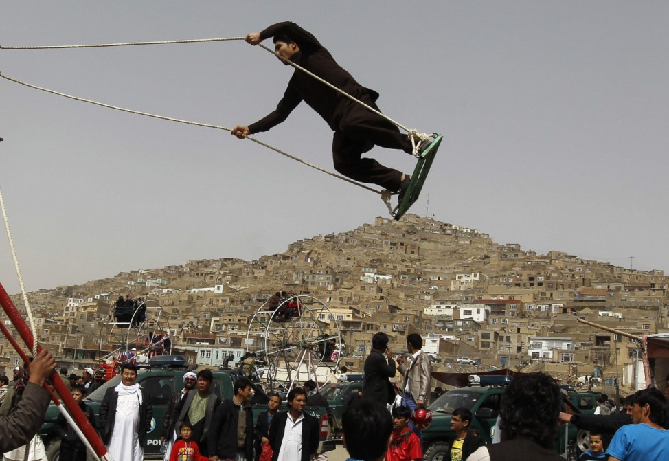 An Afghan boy plays on a swing during a gathering to celebrate the Afghan New Year (Nawroz) in Kabul