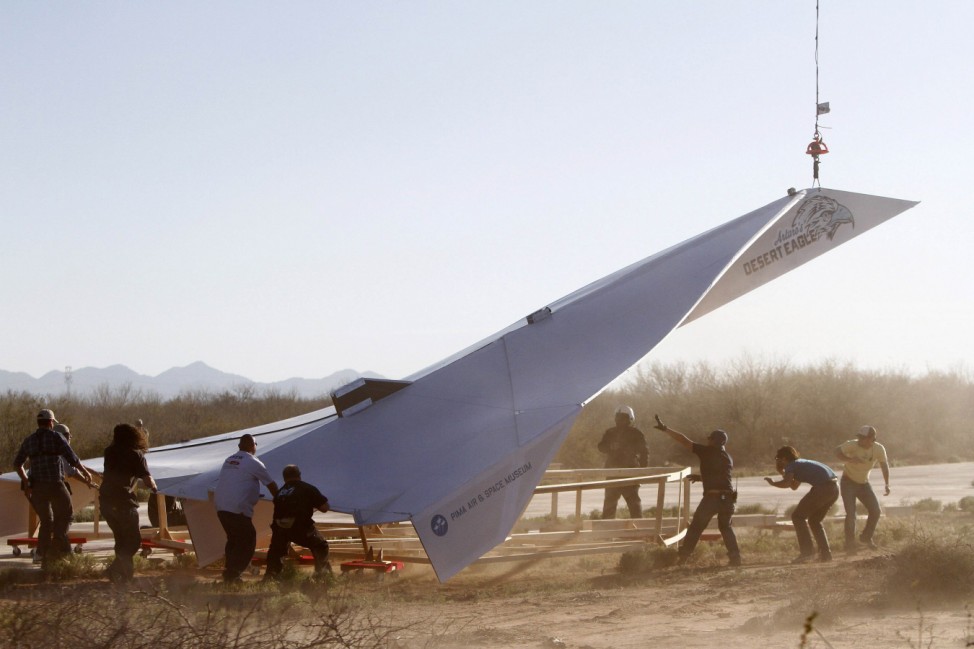 Workers prepare to launch a 45-foot paper airplane from the Pima Air and Space Museum over the desert in Eloy, Arizona