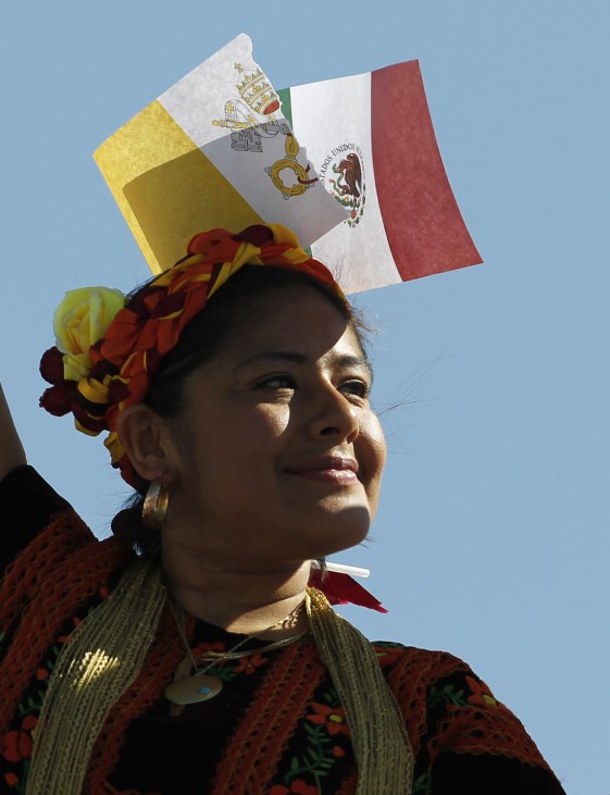 A woman dressed in a typical Mexican outfit wears the Vatican's flag and the Mexican one in her hair while awaiting the arrival of Pope Benedict XVI in Leon