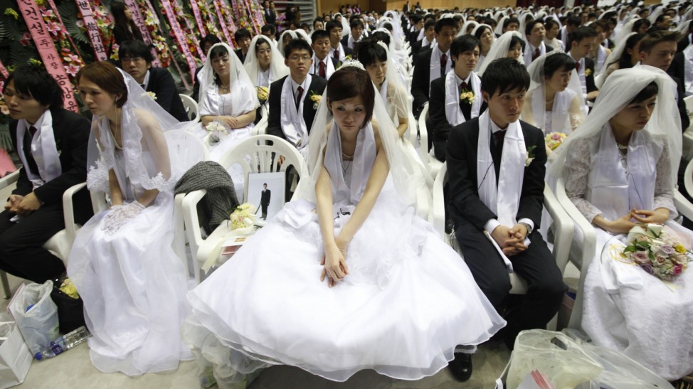 A bride attends a mass wedding ceremony of the Unification Church as a portrait of her bridegroom, who could not attend at the wedding ceremony, is seen on a chair in Gapyeong