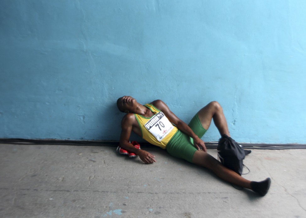 An athlete rests after his race at Inter-Secondary Schools Boys and Girls Athletics Championships in Kingston