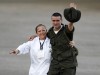 A police official held hostage by FARC rebels waves next to a medical official as he arrives at Villavicencio's airport after being freed