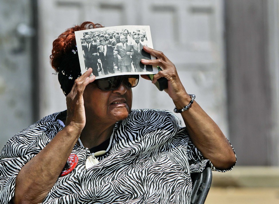 Georgia King finds shade under a program sheet commemorating Dr. Martin Luther King during a ceremony to rename Linden Avenue to 'Dr. M.L. King Jr. Avenue' in Memphis