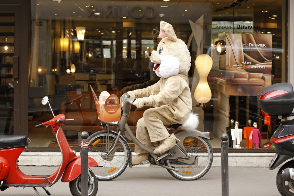 A man dressed as the Easter Bunny rides a Velib self-service public bicycle in Paris
