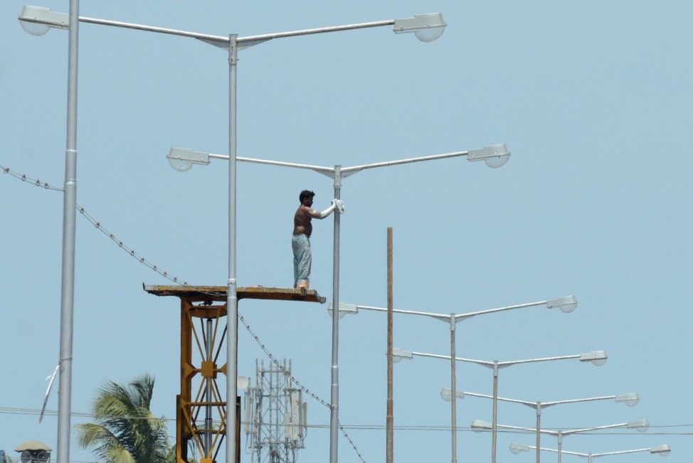 Chennai worker paints street light post