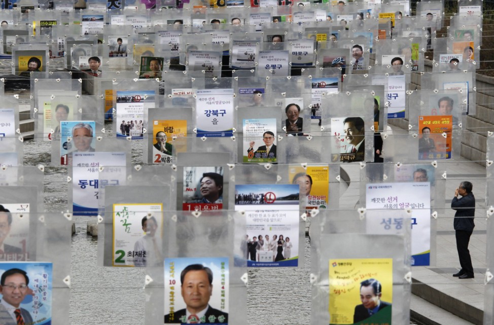 A man looks at parliamentary election posters which were installed as a campaign of boosting votes at Chunggye stream in Seoul