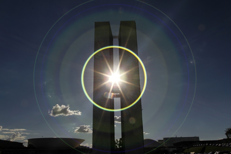 The sun causes lens flare as it is photographed between the towers of the National Congress in Brasilia
