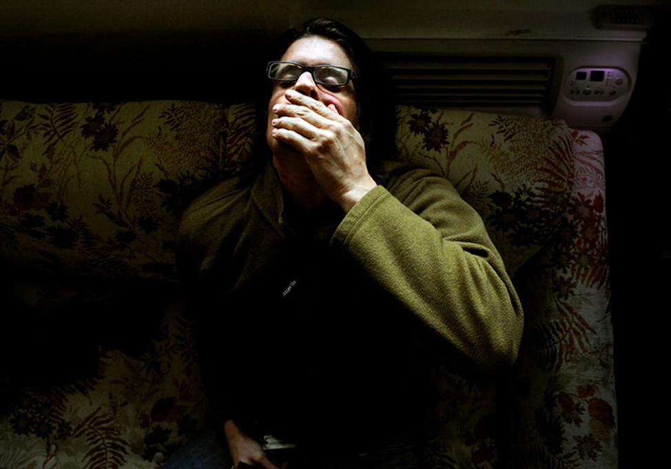Brian Scott Ostrom cups his hand over his mouth as he tries to calm a panic attack at his apartment in Boulder, Colorado