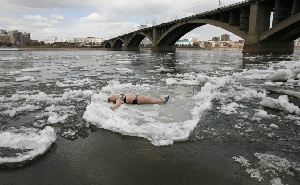 A member of the Cryophil winter swimmers club lies on floating ice from the spring melting on the Yenisei River