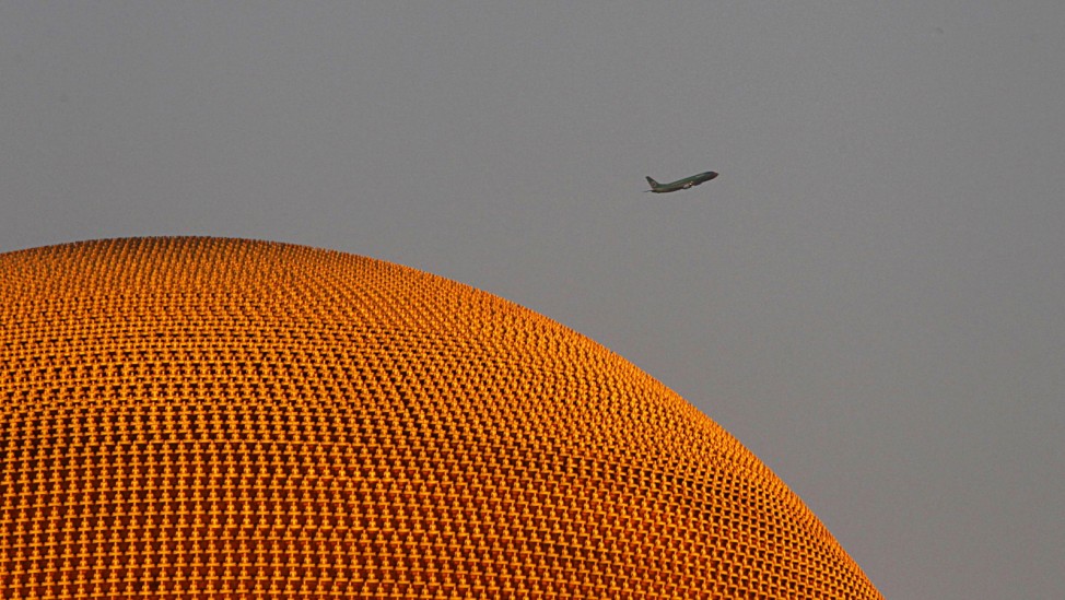 An aircraft flies past the Wat Phra Dhammakaya temple in Pathum Thani province