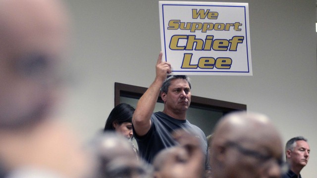 Korolowski holds up a sign in support of embattled Sanford Police Chief Lee during a special meeting by the Sanford City Commission in Sanford