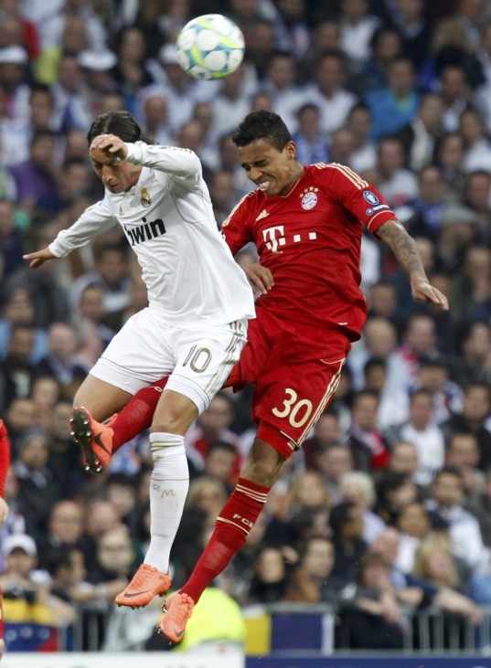 Bayern Munich's Gustavo heads the ball with Real Madrid's Ozil during their Champions League semi-final second leg soccer match at Santiago Bernabeu stadium in Madrid