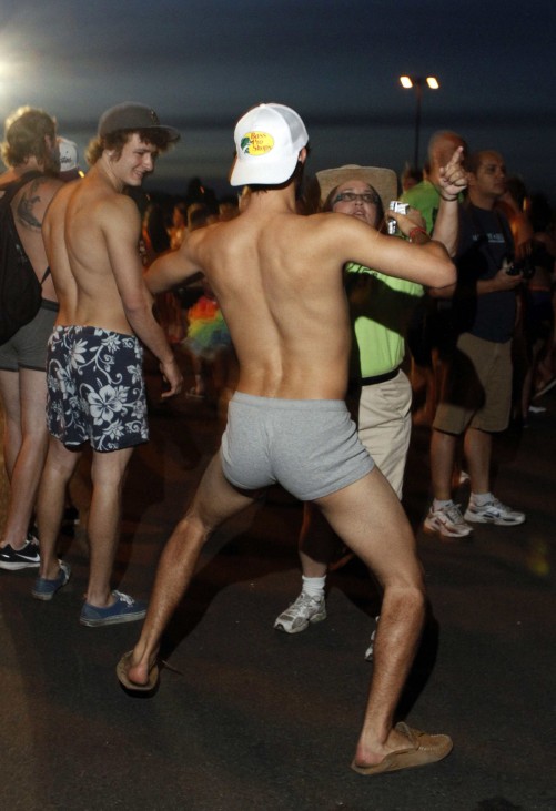 Half-naked Arizona State University student dances in front of security guard as he celebrates last day of classes by donating clothes off his back to charity during ASU Undie Run in Temp