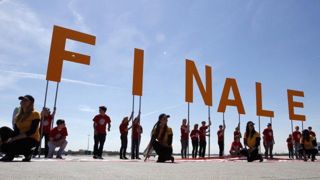 People hold up letters that read 'Final' before the arrival of the Bayern Munich soccer team at Munich's airport