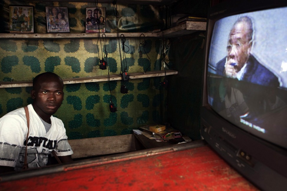 Street vendor watches live broadcast of verdict being delivered by United Nations-backed court in Hague convicting former Liberian president Charles Taylor of war crimes, in Freetown