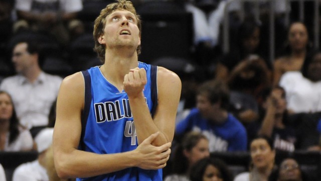 Mavericks forward Dirk Nowitzki holds his arm after falling and injuring it in the first half of their NBA basketball game against the Atlanta Hawks in Atlanta.