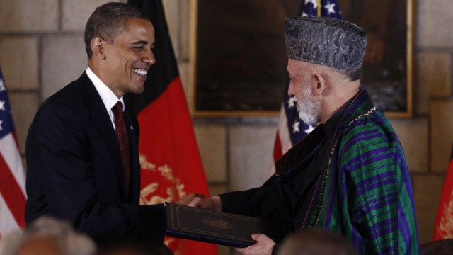 U.S. President Obama and Afghan President Karzai shake hands after signing the Strategic Partnership Agreement at the Presidential Palace in Kabul