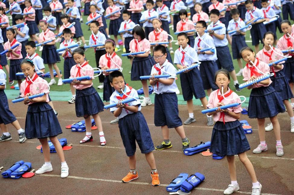 Students play melodicas during a group performance between classes at a primary school in Chongqing municipality