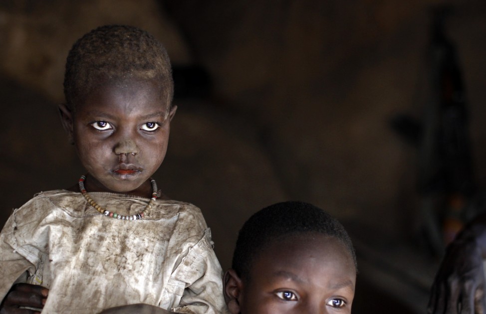 A girl and her brother sit in a cave shelter in Tess village in the rebel-held territory of the Nuba Mountains in South Kordofan
