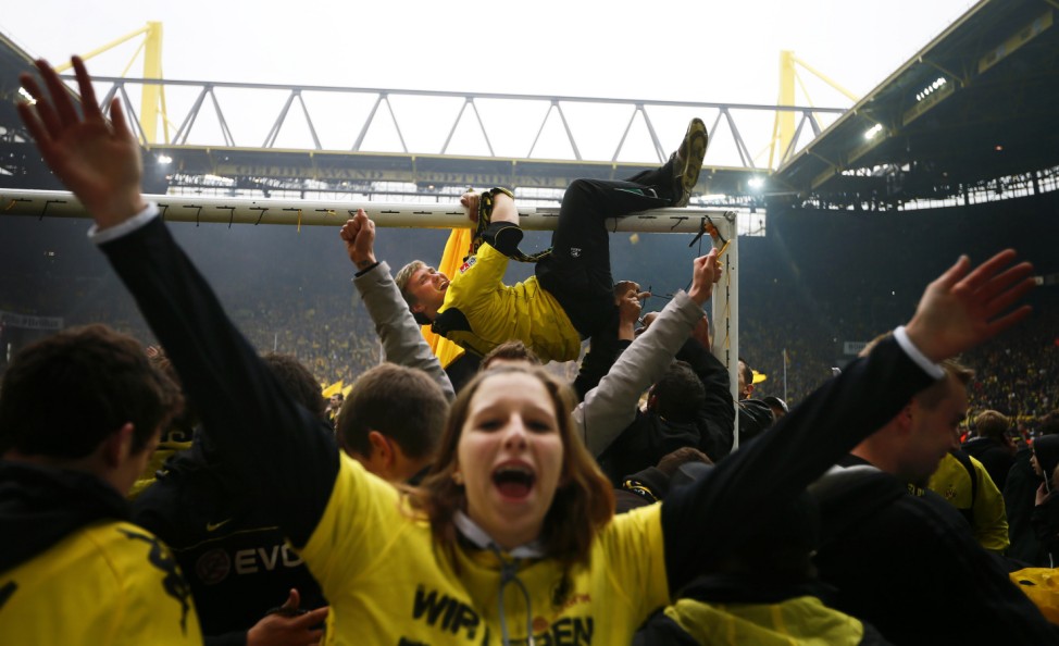 Supporters of German soccer champion (Deutscher Meister) Borussia Dortmund celebrate on the pitch after their first division Bundesliga soccer match against SC Freiburg in Dortmund