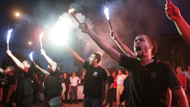 Supporters of the extreme-right Golden Dawn party raise flares as they celebrate polls results in Thessaloniki