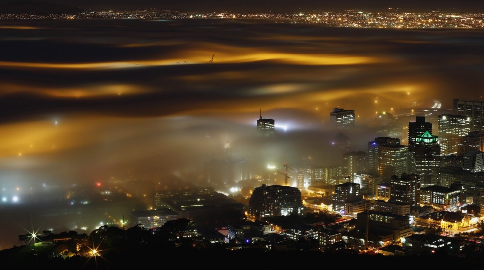 Seasonal fog is illuminated by the lights of  Cape Town harbour as the city prepares for the start of the southern hemisphere winter