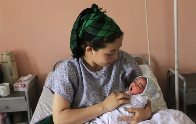 An Afghan woman holds her newborn baby at Cure International's hospital in Kabul