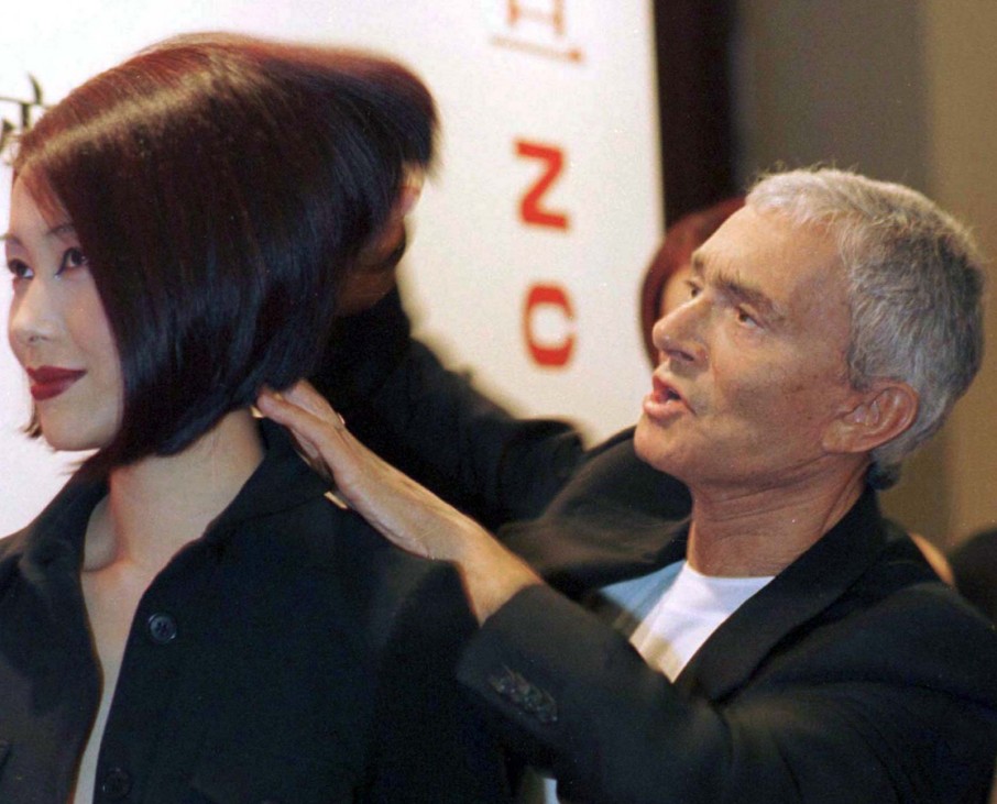 File photo of famed hairdresser Vidal Sassoon helping to style the hair of a model in Shanghai