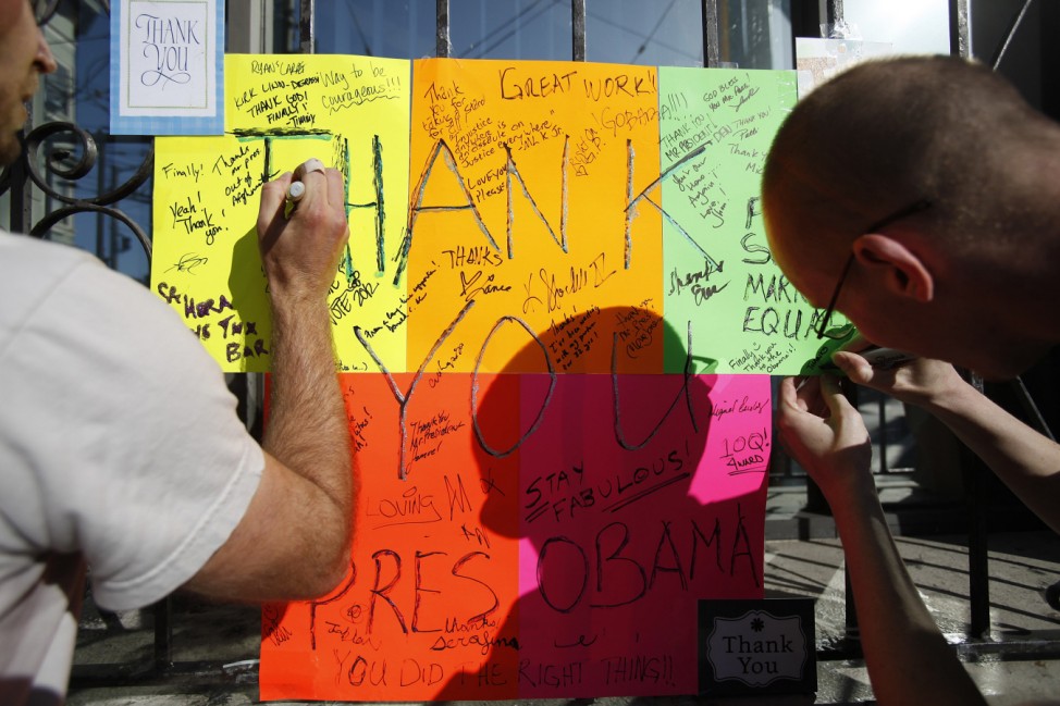 People sign a thank you card to President Obama