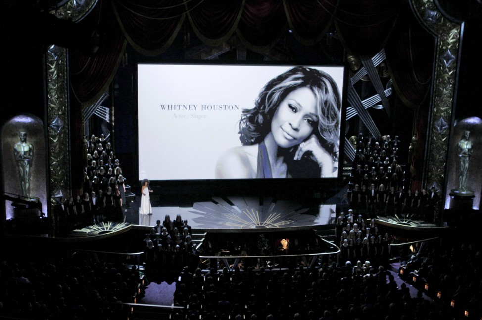 Spalding sings as a portrait of Houston is displayed on the screen during the memorial segment at the 84th Academy Awards in Hollywood