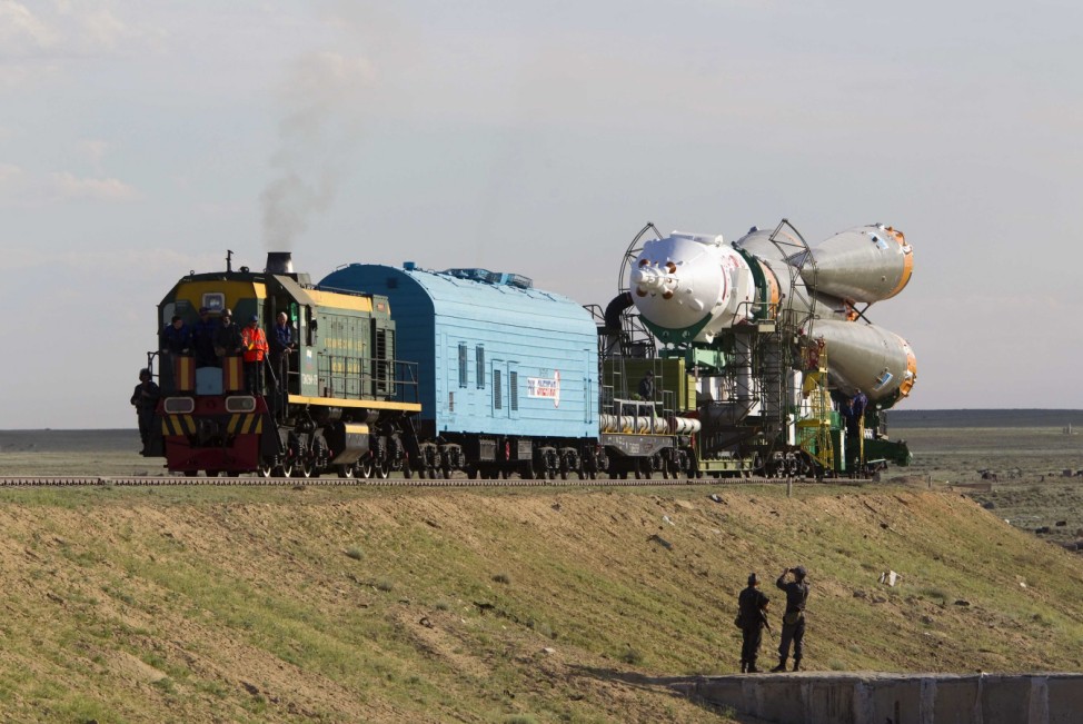 Policemen take pictures of the Soyuz TMA-04M spacecraft during transportation to its launch pad at the Baikonur cosmodrome