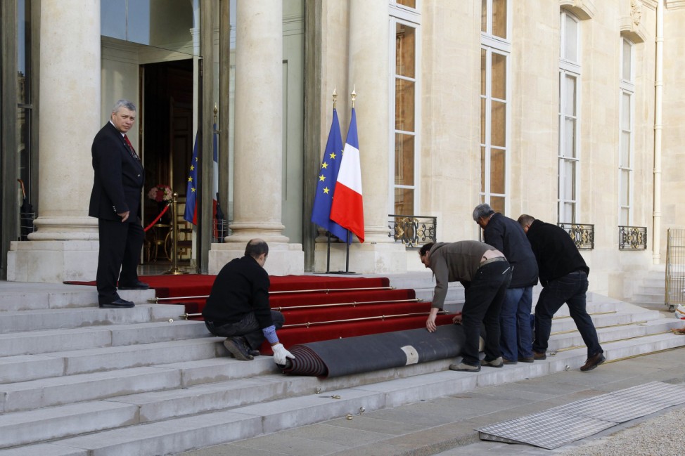 Workmen prepare the red carpet on the steps of the Elysee Palace in final preparations for the handover ceremony in Paris