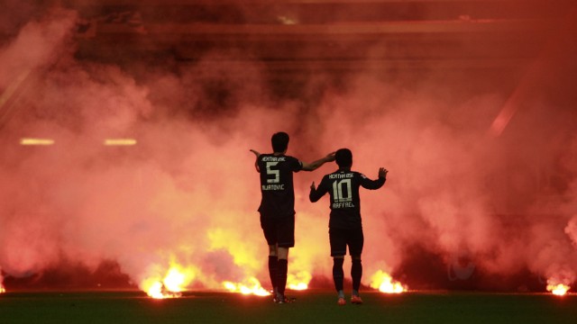 Hertha Berlin players react to flares thrown by their supporters onto the field during their German Bundesliga first division relegation soccer match against Fortuna Duesseldorf in Duesseldorf