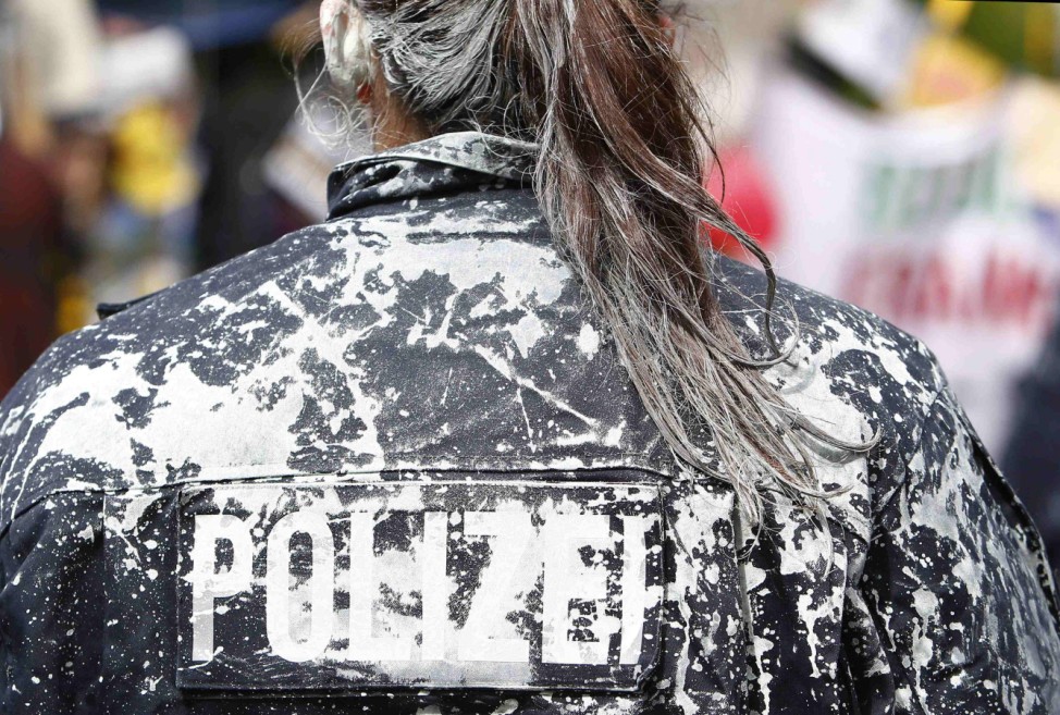 A German riot police woman is covered with paint after being attacked by demonstrators as police clears the camp of occupy protestors in front of the European Central Bank (ECB) in Frankfurt