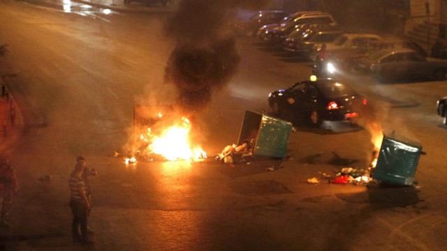 Garbage bins set on fire by Lebanese Sunni Muslim residents are seen blocking a road in Beirut
