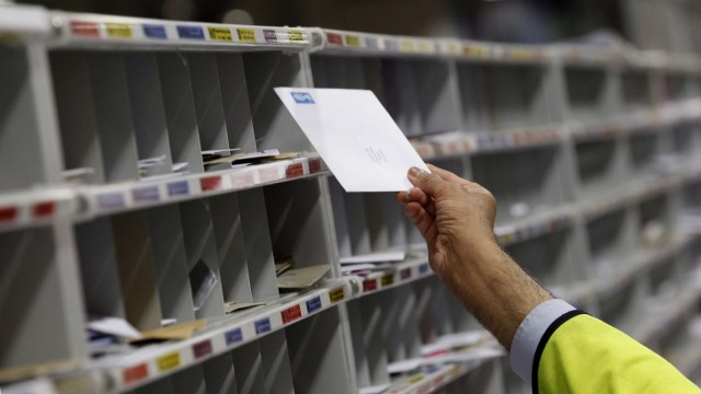 A Royal Mail employee sorts letters at the Royal Mail Mount Pleasant Sorting Office in London