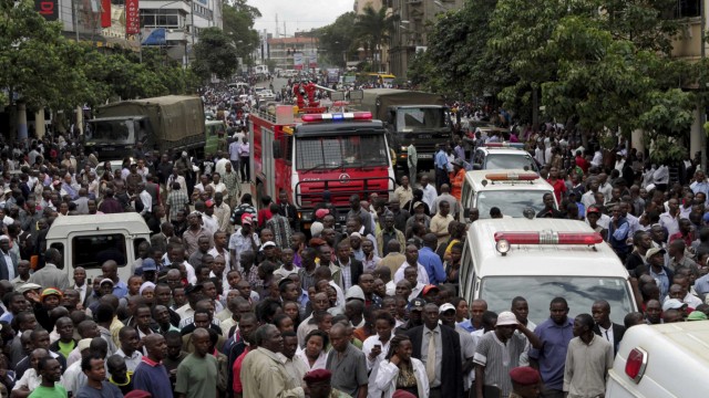 Crowds of people gather along a main street near scene of an explosion in Kenya
