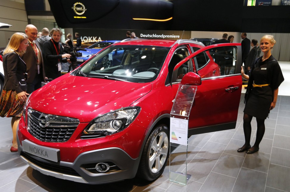 A model poses next to an Opel Mokka car at the AMI Auto Show in Leipzig
