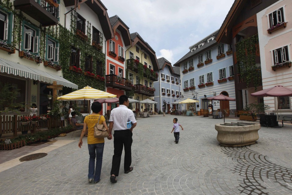 A family walks in the Chinese replica of Austria's UNESCO heritage site, Hallstatt village, in China's southern city of Huizhou
